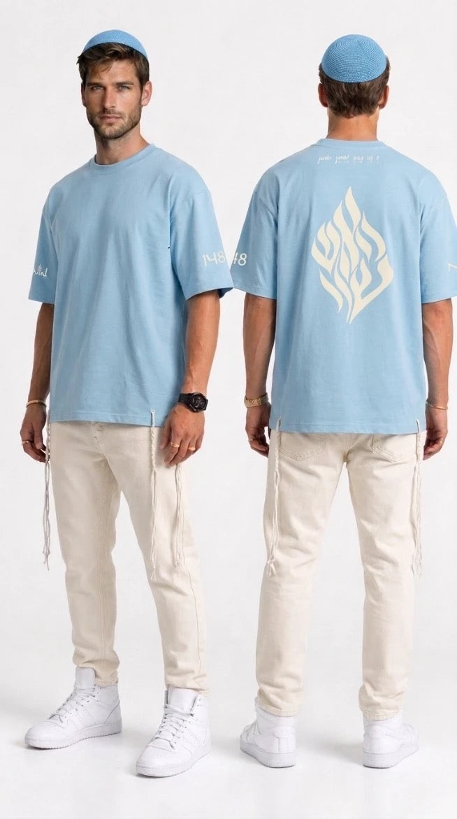 T-shirt tsitsit Tehelet bleu ciel NAHAL porté par un modèle — vue avant et arrière, flame brodé crème, oversize avec tsitsit